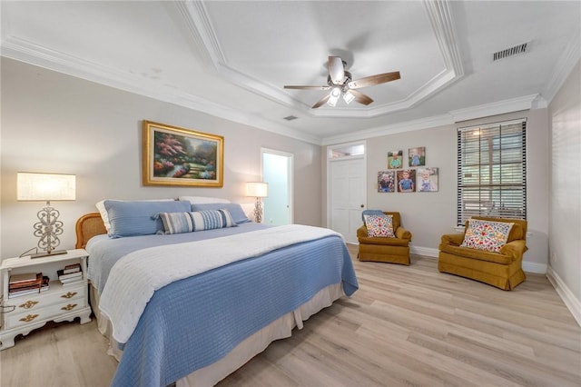 bedroom with a raised ceiling, ceiling fan, light hardwood / wood-style floors, and ornamental molding