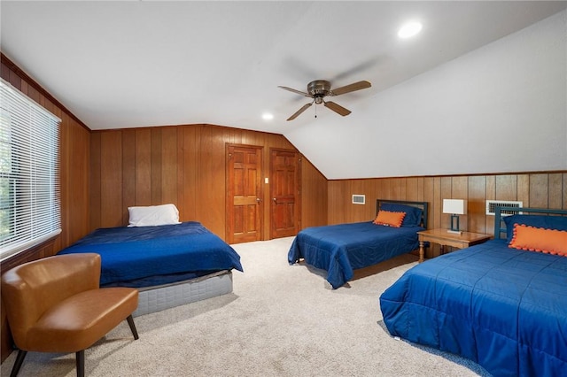 bedroom with ceiling fan, wood walls, lofted ceiling, and light carpet