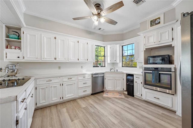 kitchen with white cabinets, ornamental molding, and black appliances