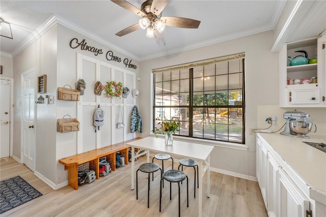 dining room with light wood-type flooring, ceiling fan, and crown molding