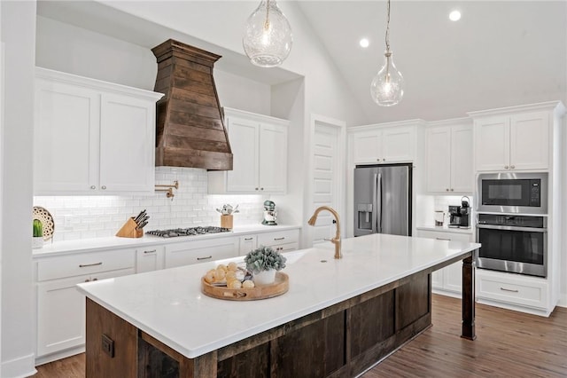 3518 Parmer Creek Ct, College Station, TX 77845 - kitchen featuring stainless steel appliances, custom exhaust hood, decorative backsplash, a center island with sink, and white cabinetry