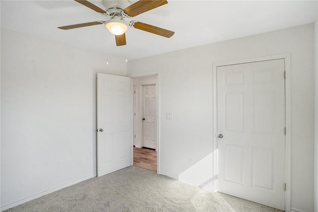 unfurnished bedroom featuring carpet, a ceiling fan, and baseboards