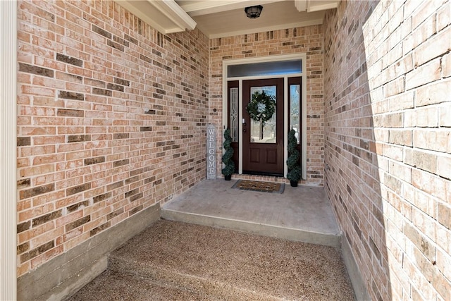 doorway to property featuring brick siding