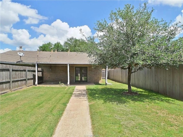 rear view of property with a lawn and french doors