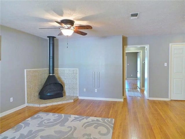 living room with light hardwood / wood-style floors and a wood stove