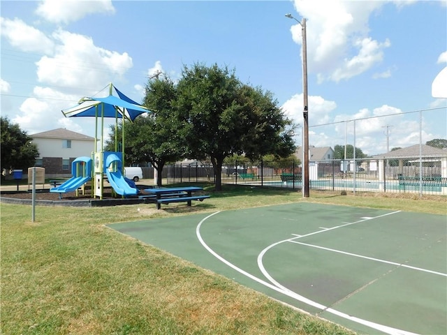 view of basketball court featuring a yard and a playground