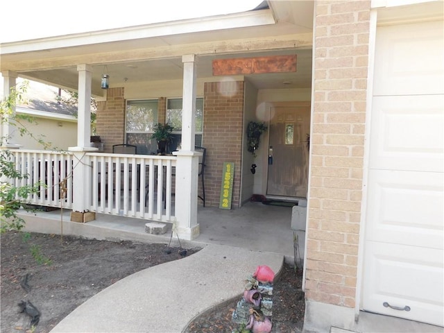 entrance to property featuring a porch and a garage