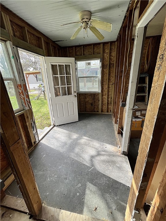 unfurnished sunroom with ceiling fan