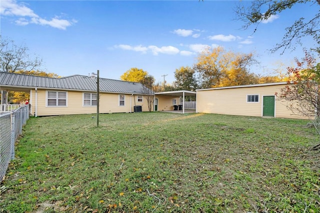 rear view of property featuring cooling unit and a yard