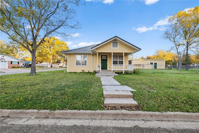 bungalow-style house featuring covered porch and a front yard