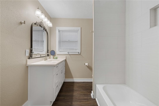 bathroom featuring hardwood / wood-style flooring, a bathtub, and vanity