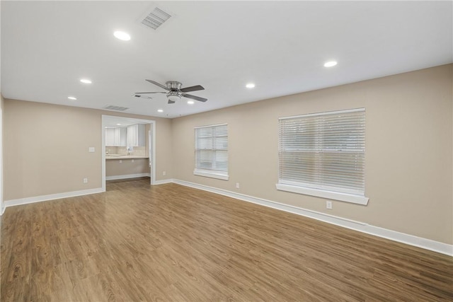 unfurnished living room featuring wood-type flooring and ceiling fan