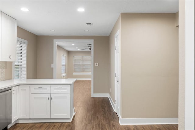 kitchen with white cabinets, kitchen peninsula, stainless steel dishwasher, ceiling fan, and wood-type flooring