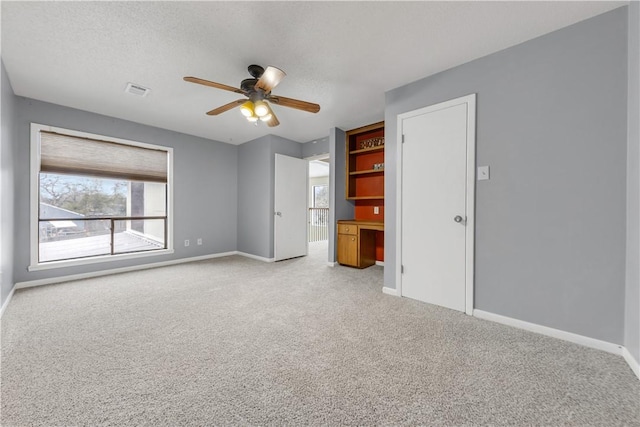 unfurnished bedroom featuring a textured ceiling, ceiling fan, and light carpet