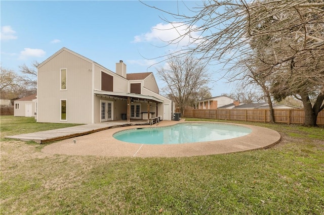 view of pool with french doors, a patio, central AC, and a lawn