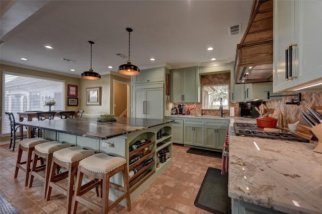 3151 Running River Ln, Washington, TX 77880 - kitchen with green cabinetry, paneled built in refrigerator, tasteful backsplash, a kitchen breakfast bar, and recessed lighting