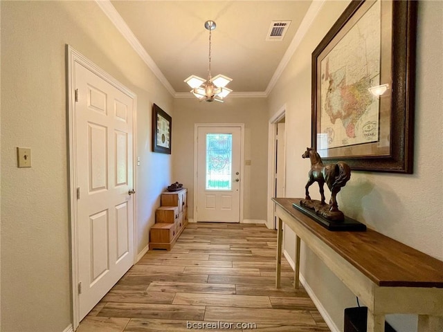 doorway to outside with a chandelier, light hardwood / wood-style floors, and crown molding