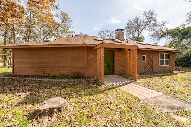 rear view of property with a lawn