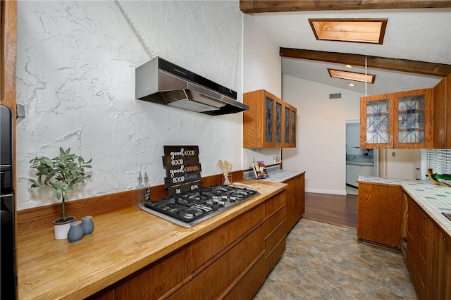 kitchen featuring hanging light fixtures, stainless steel gas cooktop, and vaulted ceiling with beams