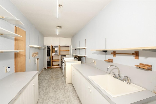 washroom with cabinets, separate washer and dryer, sink, and water heater