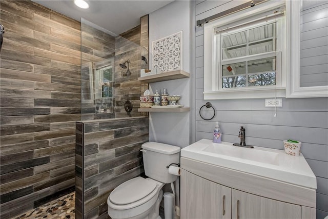 bathroom with vanity, toilet, and a tile shower