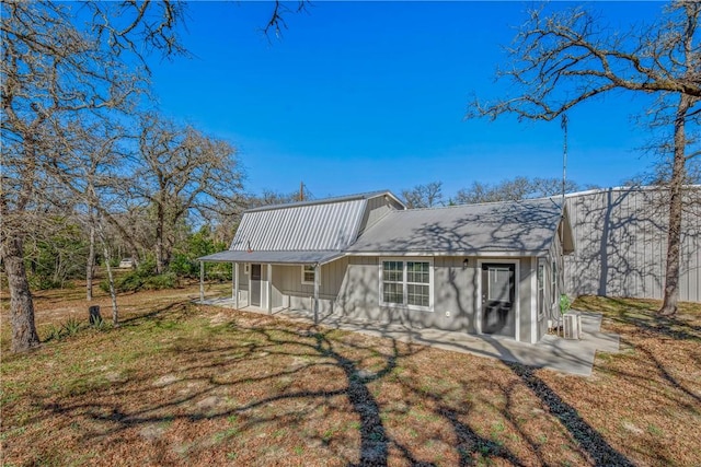 rear view of property featuring a lawn and a patio