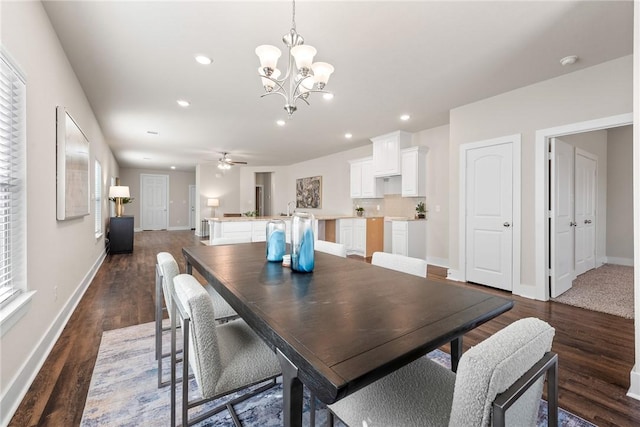 dining space featuring ceiling fan with notable chandelier and dark hardwood / wood-style floors