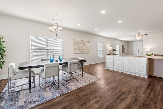 dining area featuring dark hardwood / wood-style flooring, ceiling fan with notable chandelier, and sink