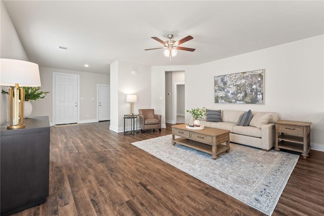 living room featuring ceiling fan and dark hardwood / wood-style flooring