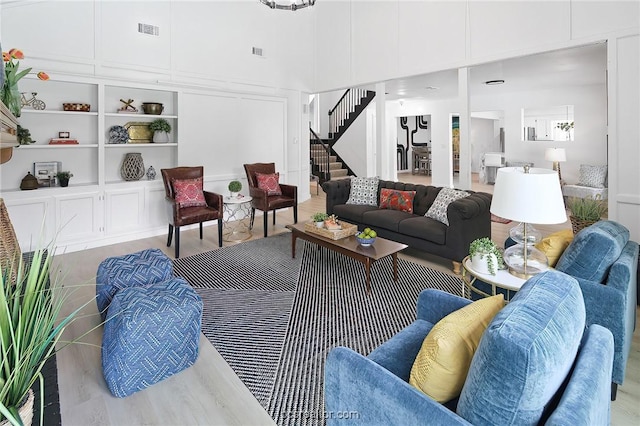 living room with light hardwood / wood-style floors and built in features