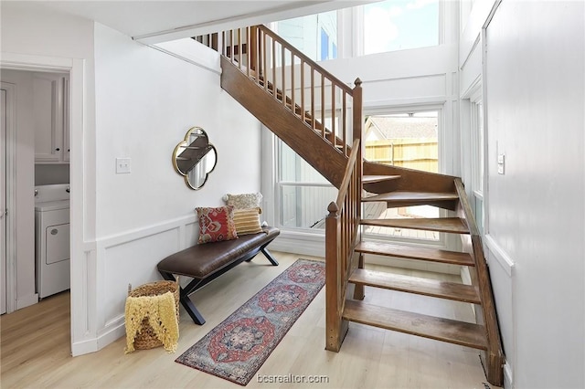 staircase with washer / dryer and wood-type flooring