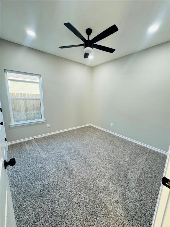 spare room featuring carpet floors and ceiling fan