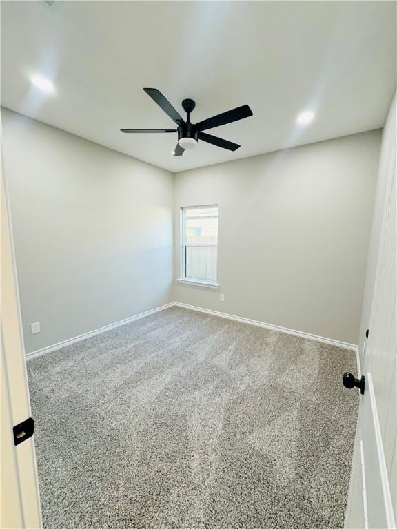 unfurnished room featuring ceiling fan and carpet floors