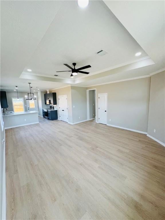 unfurnished living room featuring light wood-type flooring, a raised ceiling, and ceiling fan