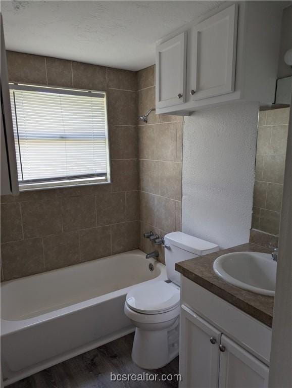 full bathroom with vanity, toilet, wood-type flooring, and tiled shower / bath