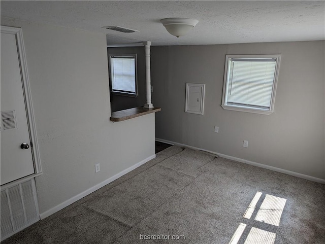 carpeted empty room with a textured ceiling