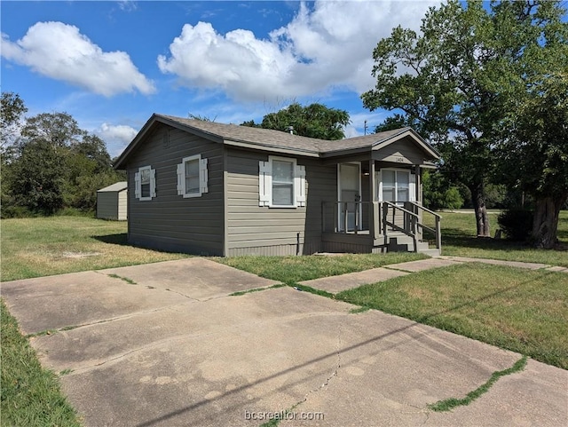 view of front of home featuring a front yard and an outdoor structure