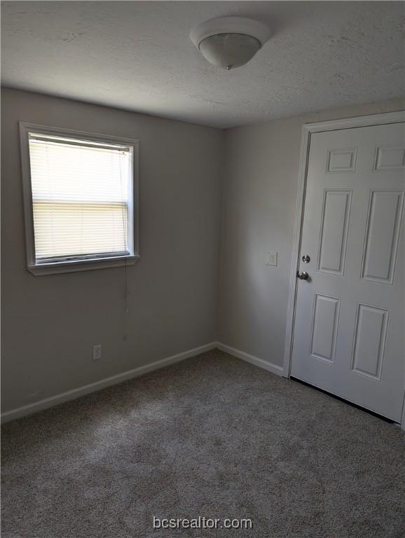 carpeted spare room featuring a textured ceiling