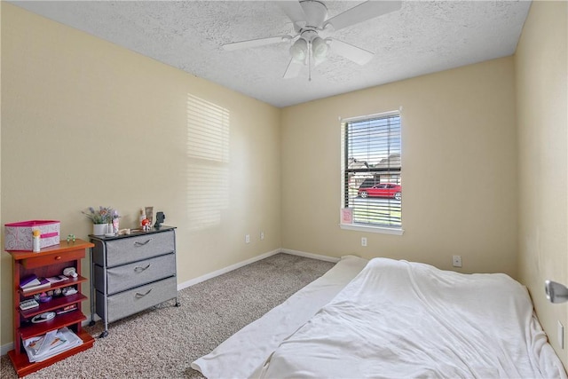 bedroom featuring ceiling fan, light colored carpet, and a textured ceiling