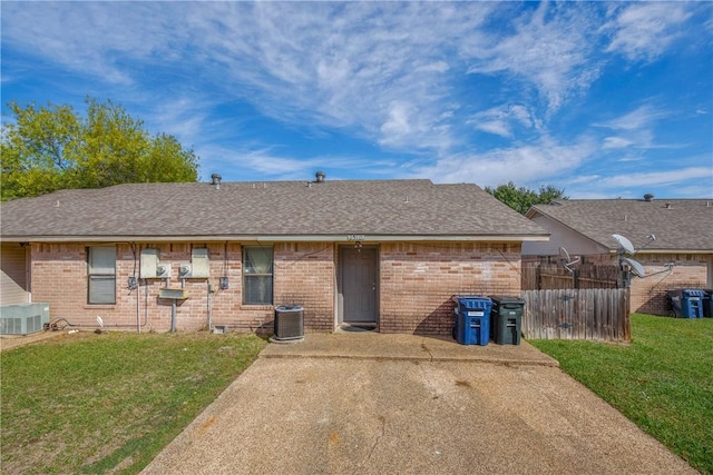 back of house with a yard and central AC