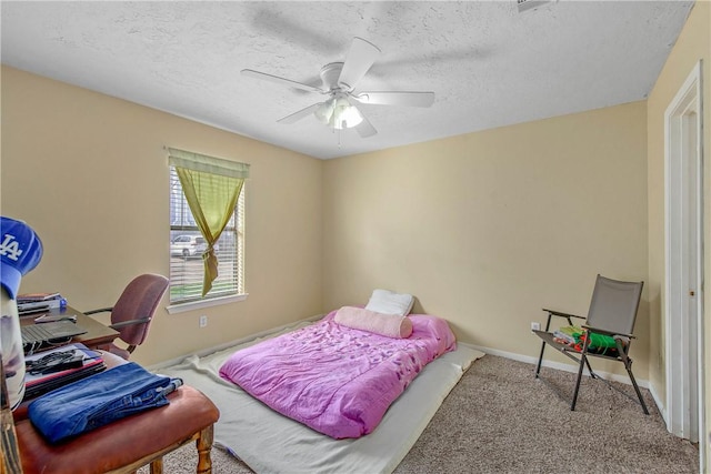 bedroom with ceiling fan, carpet floors, and a textured ceiling