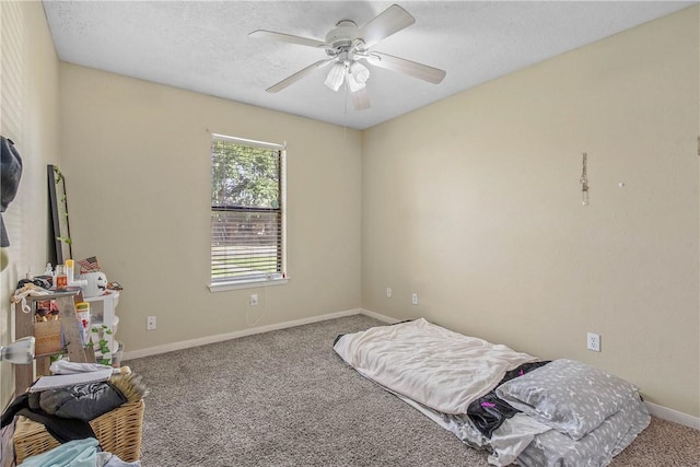 carpeted bedroom featuring ceiling fan and a textured ceiling