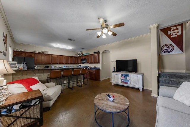 living room with a textured ceiling, ornamental molding, and ceiling fan