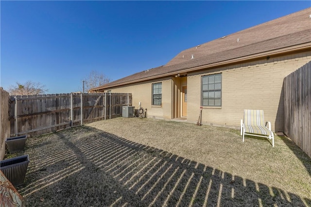 rear view of property featuring central AC and a yard