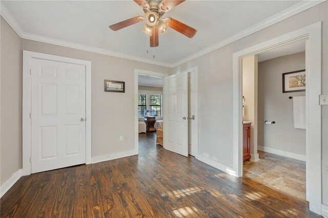 unfurnished bedroom with ceiling fan, crown molding, dark wood-type flooring, and ensuite bath