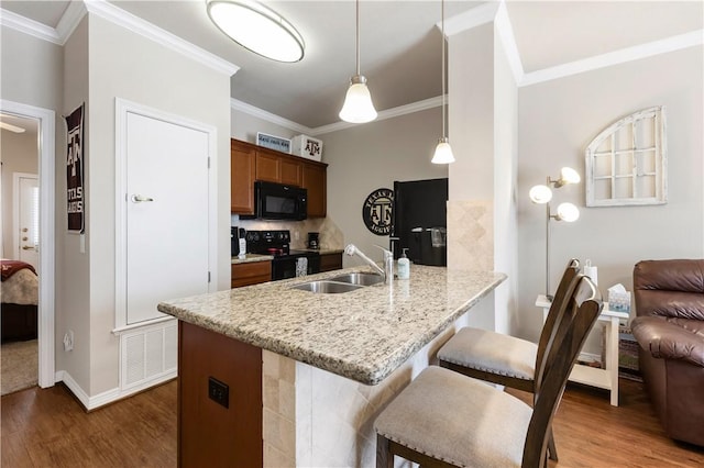 1198 Jones Butler Rd Unit 3103, College Station, TX 77840 - kitchen featuring black appliances, a sink, dark wood-type flooring, a breakfast bar area, and ornamental molding