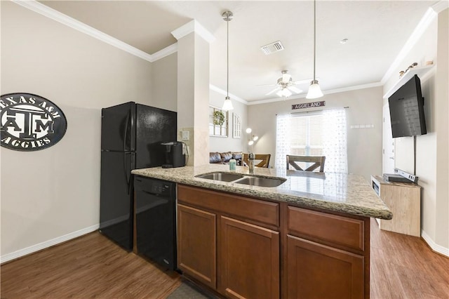 1198 Jones Butler Rd Unit 3103, College Station, TX 77840 - kitchen featuring black appliances, a sink, wood finished floors, a peninsula, and light stone counters