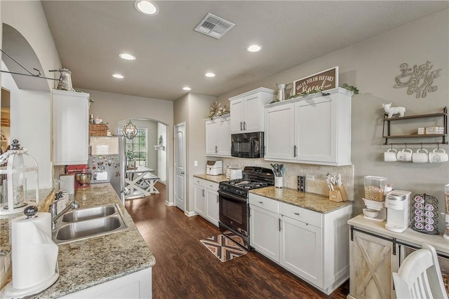 kitchen with dark wood-type flooring, sink, light stone counters, black appliances, and white cabinets