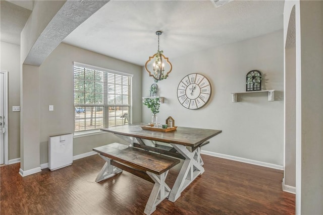 dining room featuring an inviting chandelier and dark hardwood / wood-style flooring