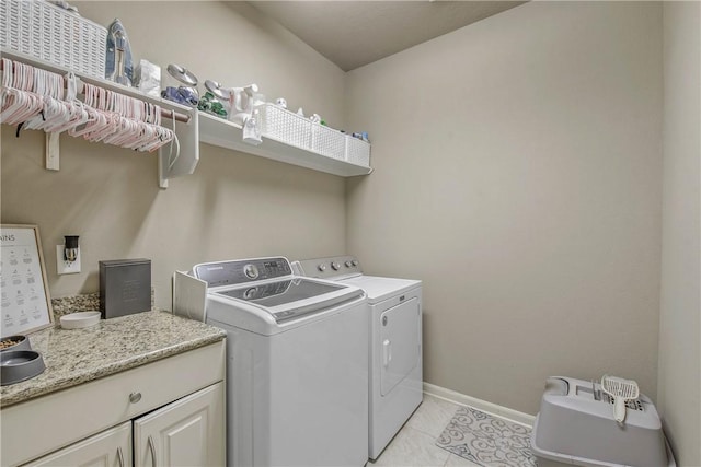 laundry room featuring cabinets, light tile patterned flooring, and washer and dryer